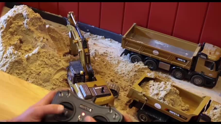 Remote controller, model excavator and dump trucks in a demonstration